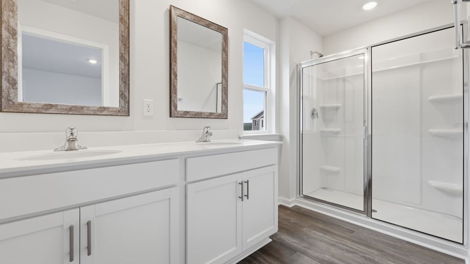 Bathroom with double vanity sink and walk in shower.