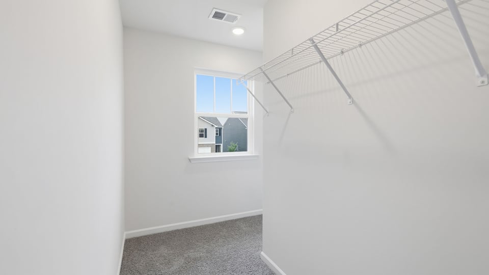 Closet with carpet and window.
