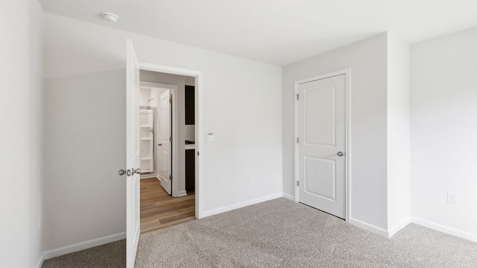 Bedroom with carpet and window.