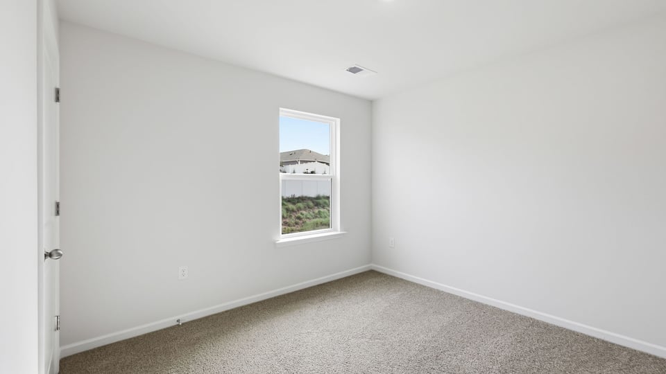Bedroom with carpet and window.