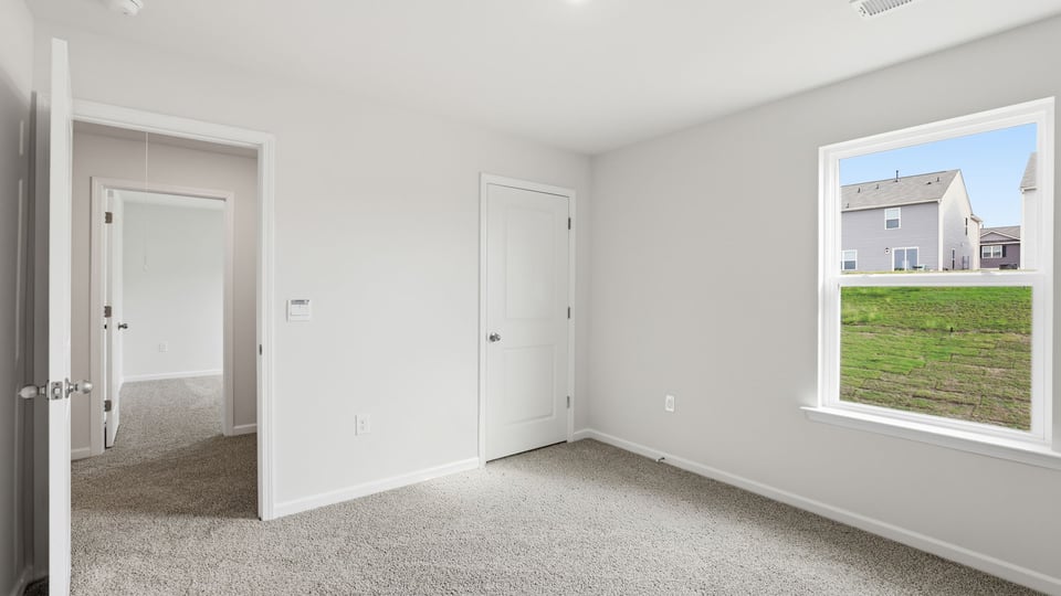 Bedroom with carpet and window.