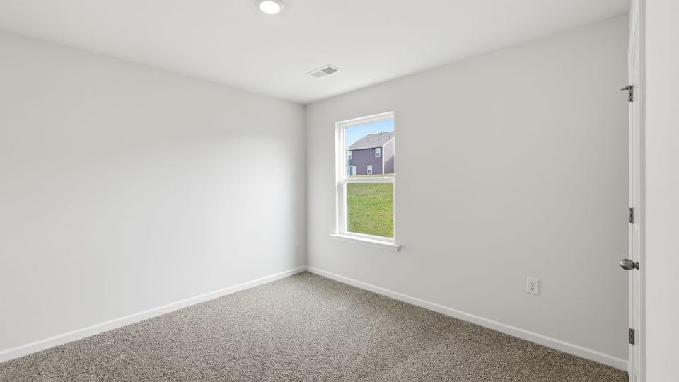 Bedroom with carpet and window.