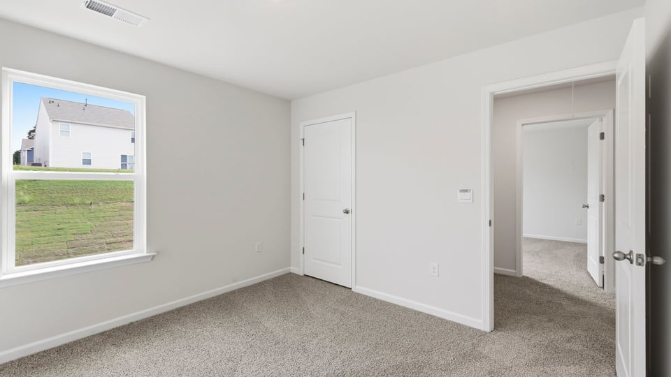 Bedroom with carpet and window.