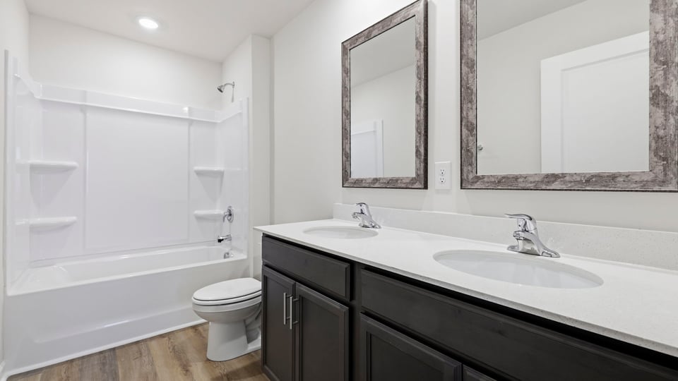 Bathroom with double vanity sink and walk in tub.