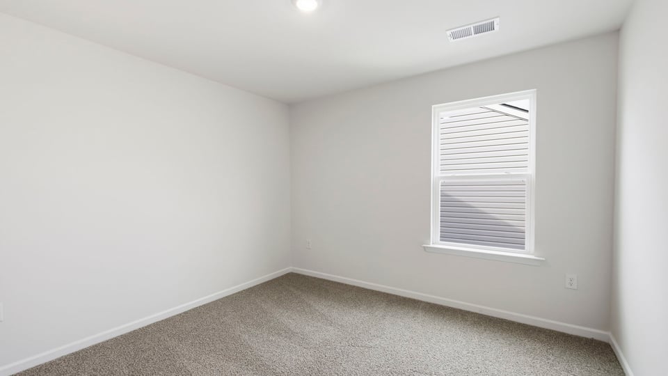 Bedroom with carpet and window.
