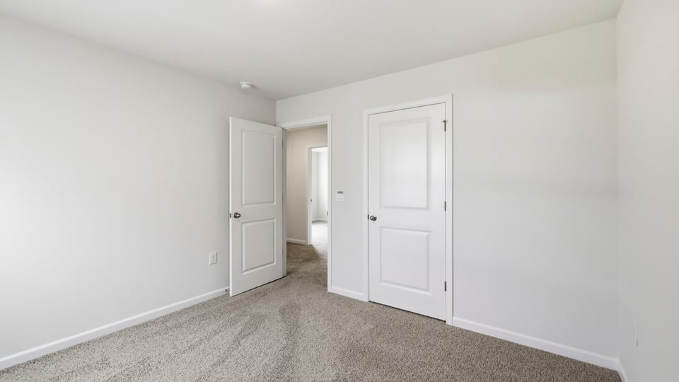 Bedroom with carpet and window.