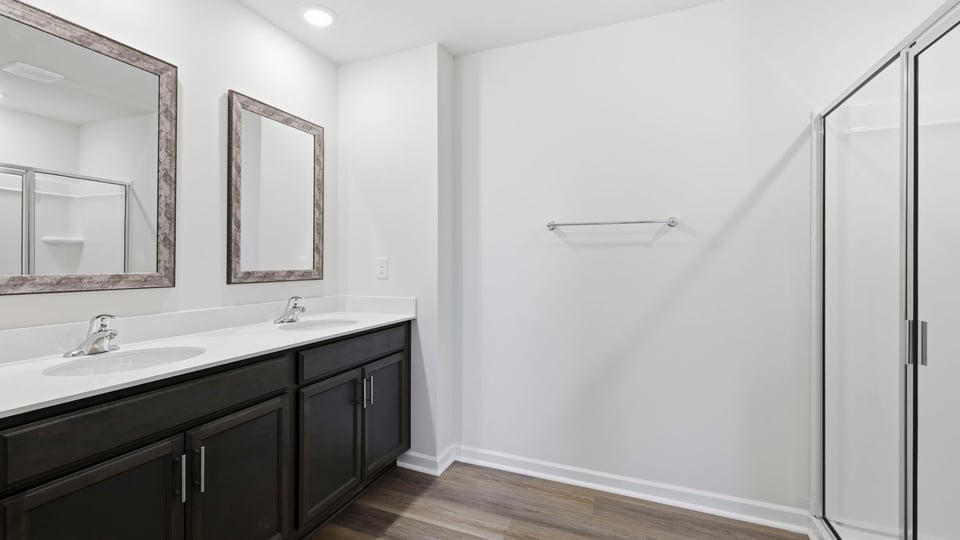 Bathroom with double vanity sink and walk in shower.