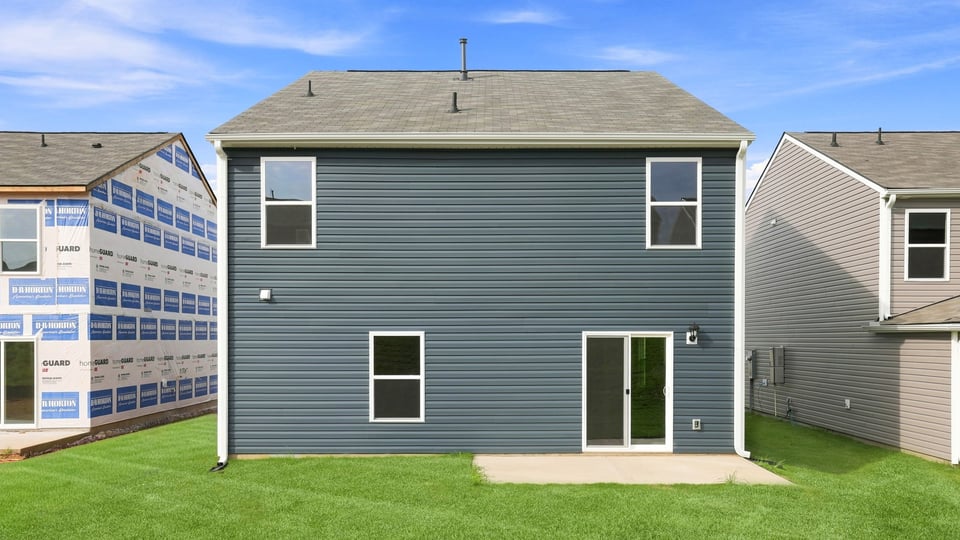 Back exterior of home with large backyard.