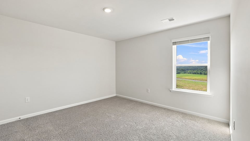 Bedroom with carpet and windows.