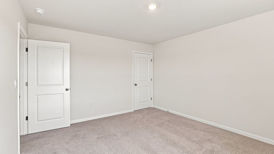 Bedroom with carpet and windows.