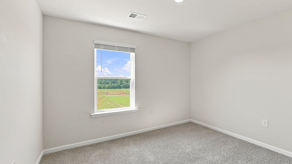 Bedroom with carpet and windows.