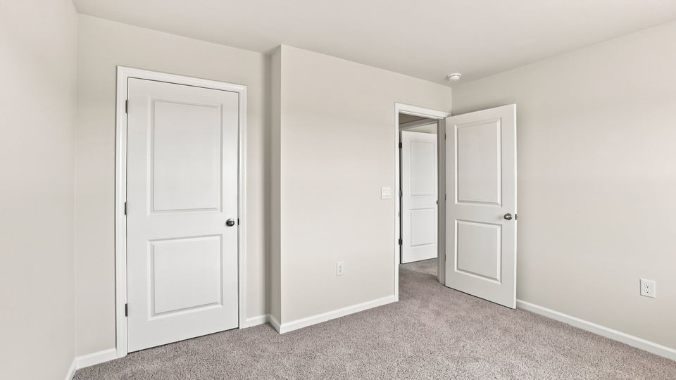 Bedroom with carpet and windows.