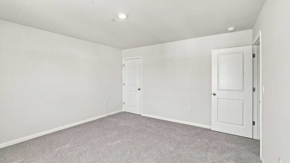 Bedroom with carpet and windows.
