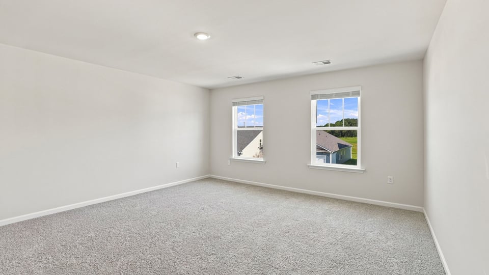 Bedroom with carpet and windows.