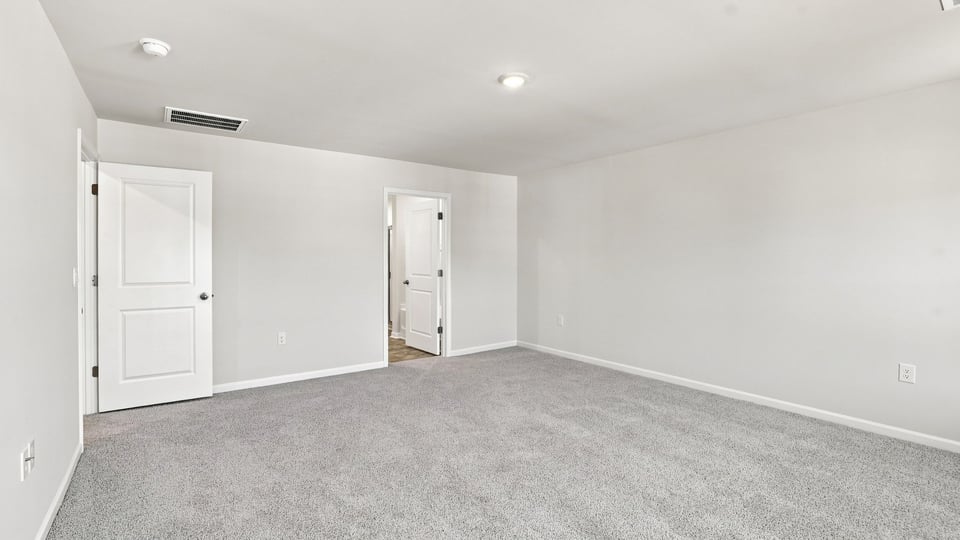 Bedroom with carpet and windows.