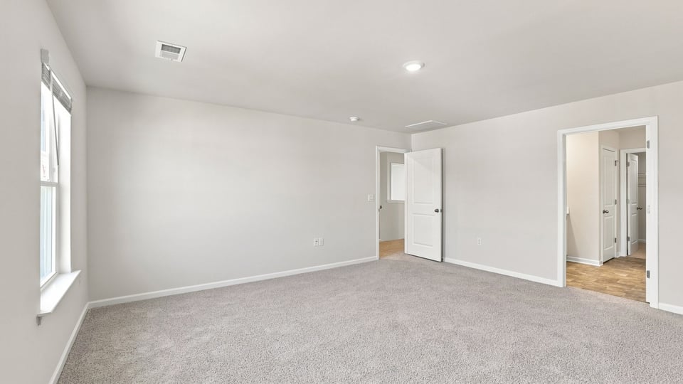 Bedroom with carpet and windows.