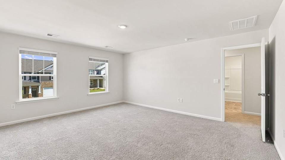 Bedroom with carpet and windows.