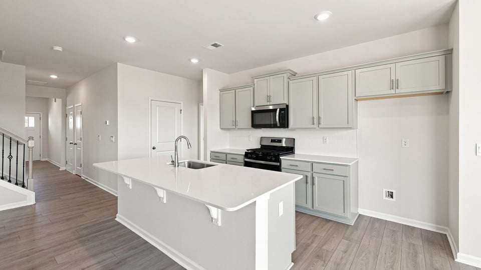 Kitchen and island with quartz countertops.