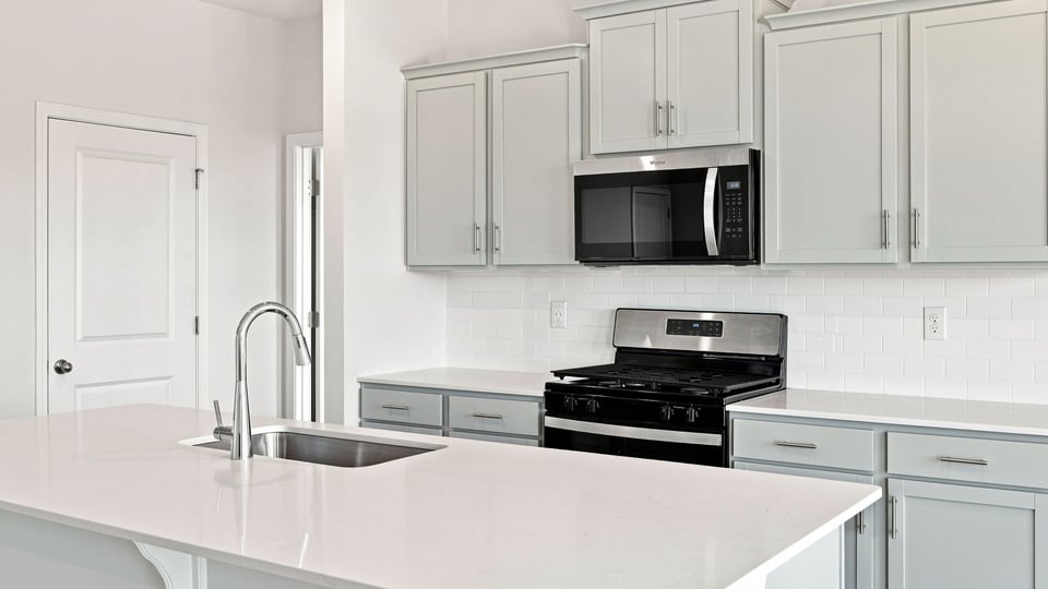 Kitchen and island with quartz countertops.