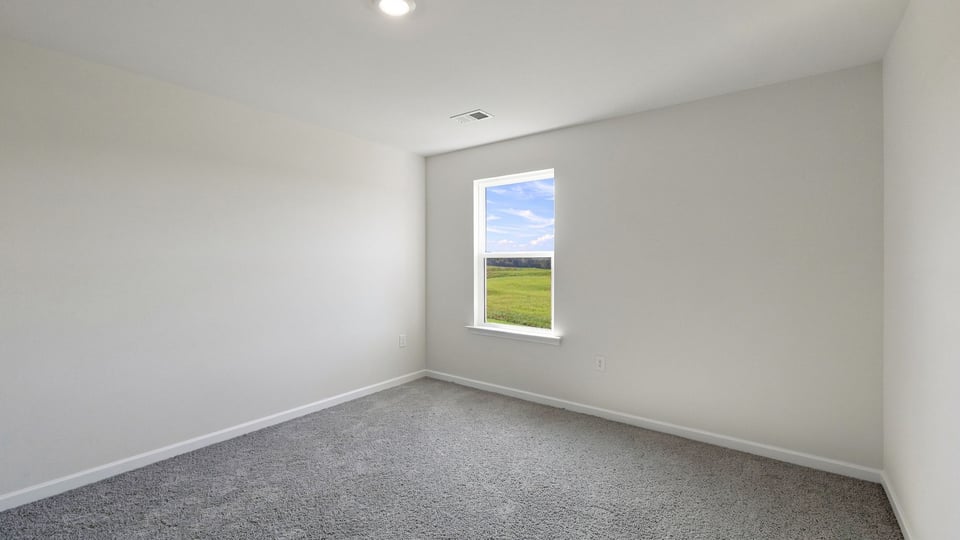 Bedroom with carpet and window.