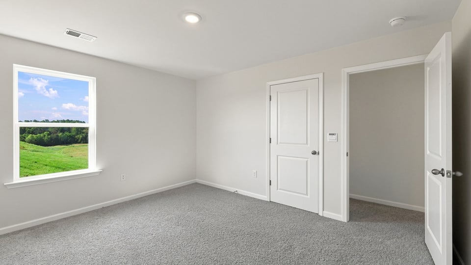 Bedroom with carpet and window.