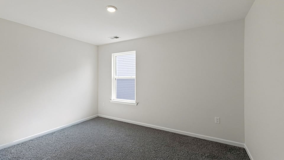 Bedroom with carpet and window.