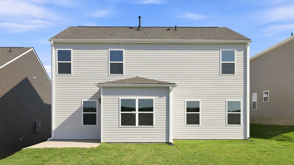 Back exterior of home with large backyard.