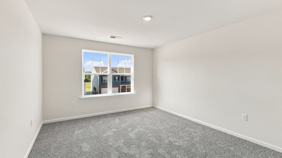 Bedroom with carpet and window.