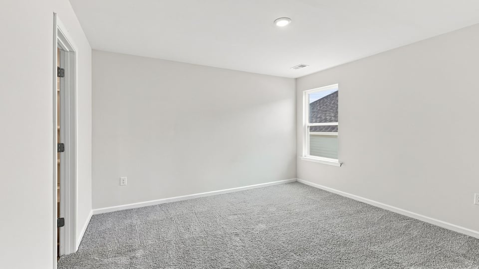 Bedroom with carpet and window.