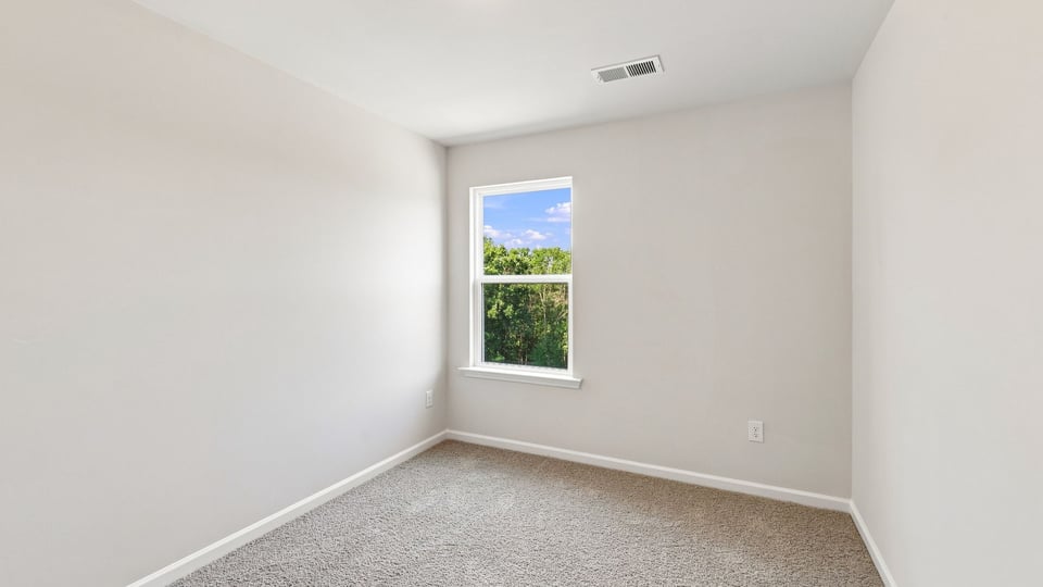Bedroom with carpet and window.