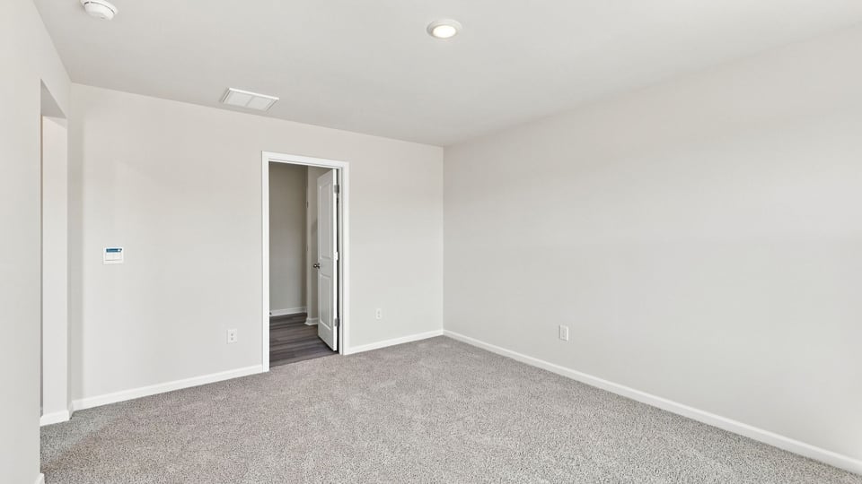 Bedroom with carpet and window.