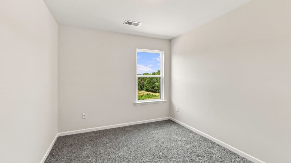Bedroom with caarpet and window.