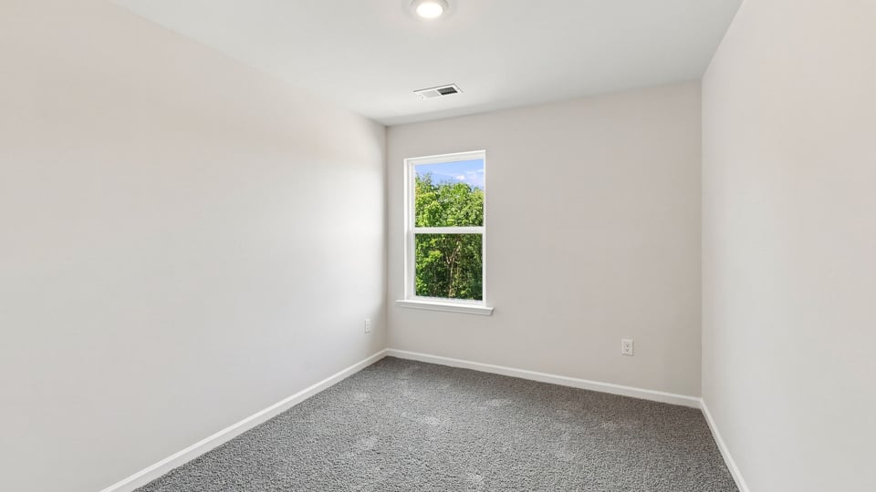 Bedroom with carpet and window.