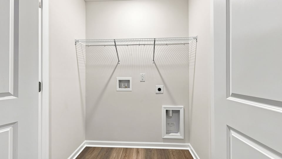 Laundry room with hanging storage racks.