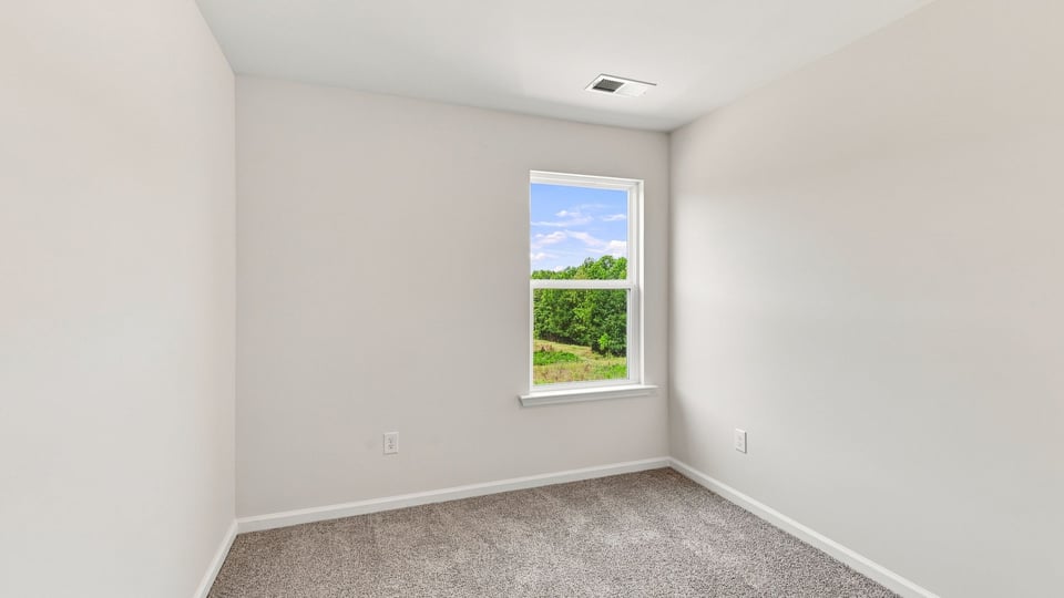 Bedroom with caarpet and window.