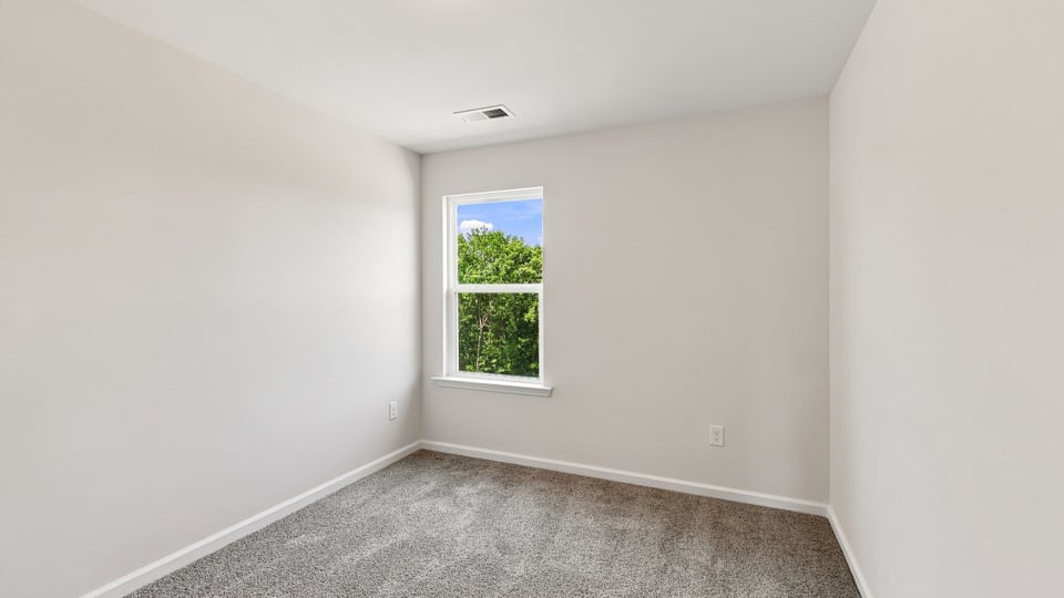 Bedroom with carpet and window.