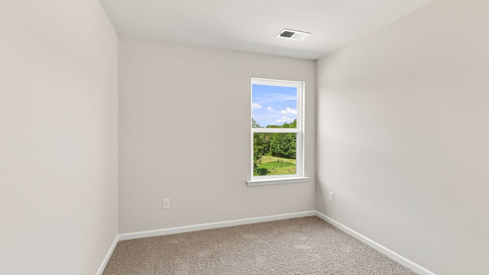 Bedroom with carpet and window.
