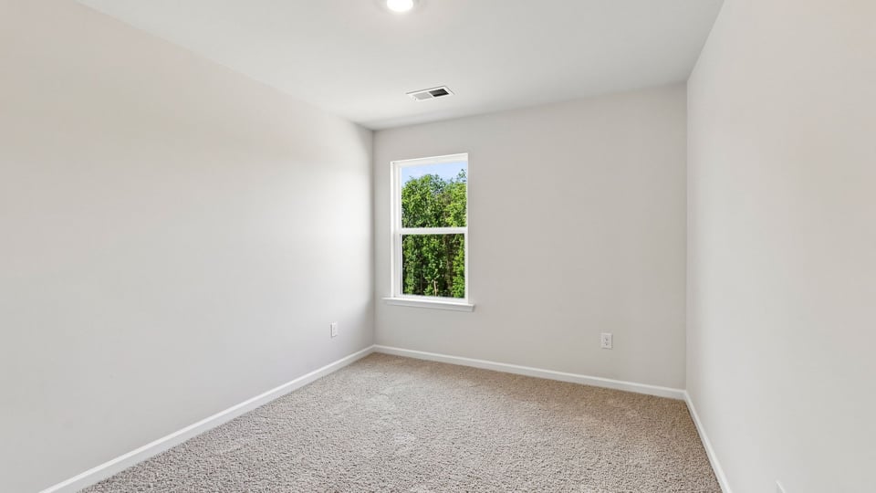Bedroom with carpet and window.
