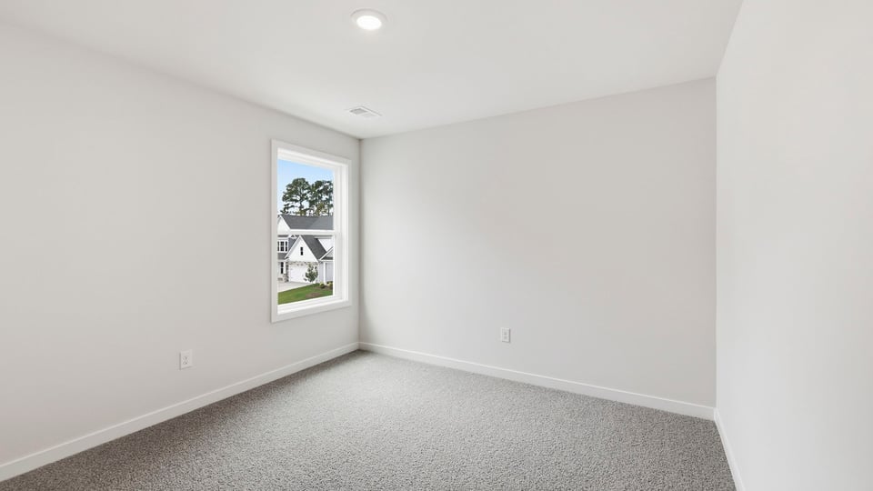 Bedroom with carpet and window.