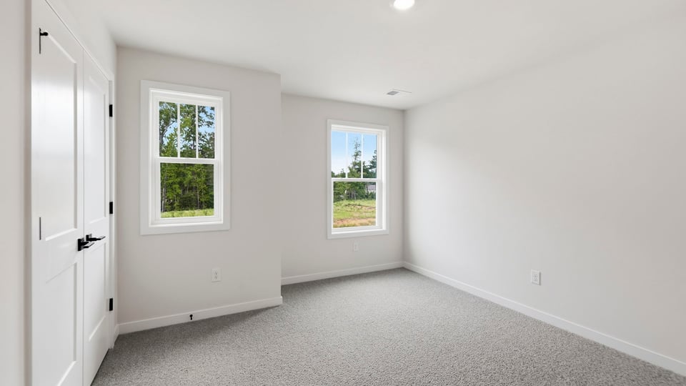 Bedroom with carpet and window.