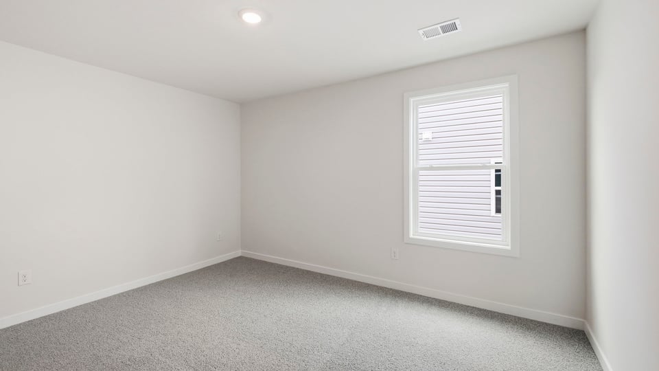 Bedroom with carpet and window.