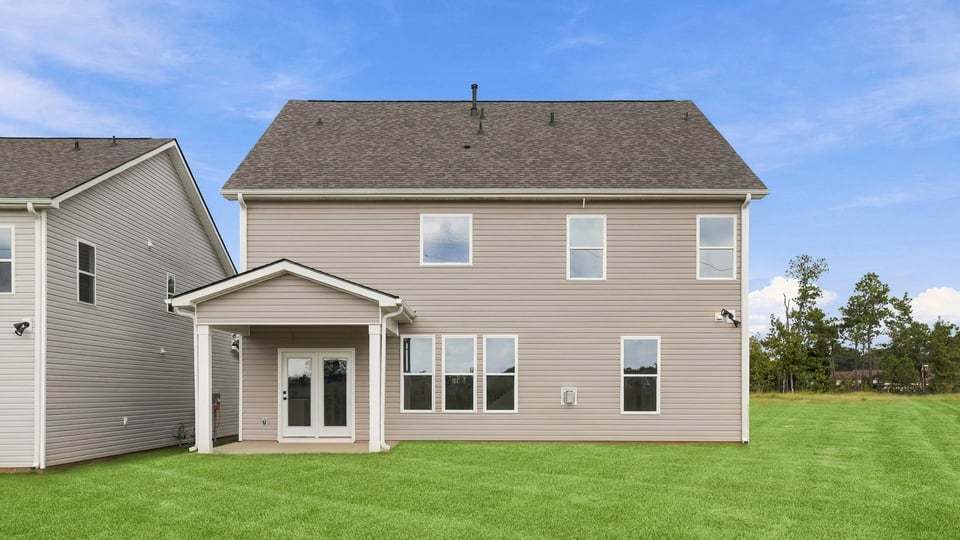 Back exterior of home with large backyard.