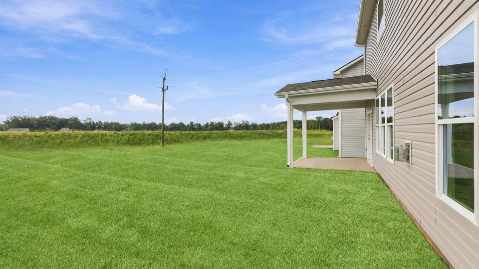 Back exterior of home with covered patio.