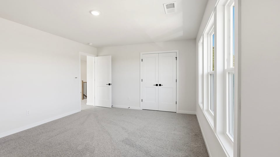 Bedroom with carpet and window.