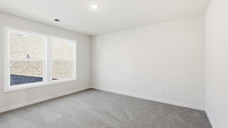 Bedroom with carpet and window.