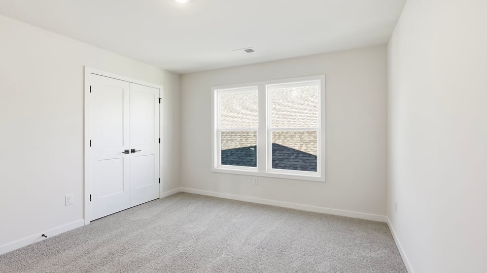 Bedroom with carpet and window.