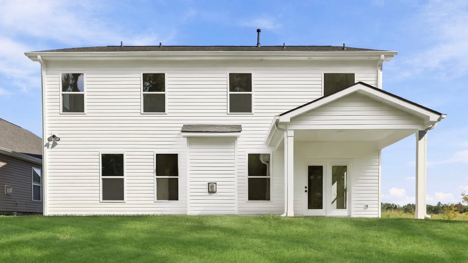Back exterior of home with large backyard.