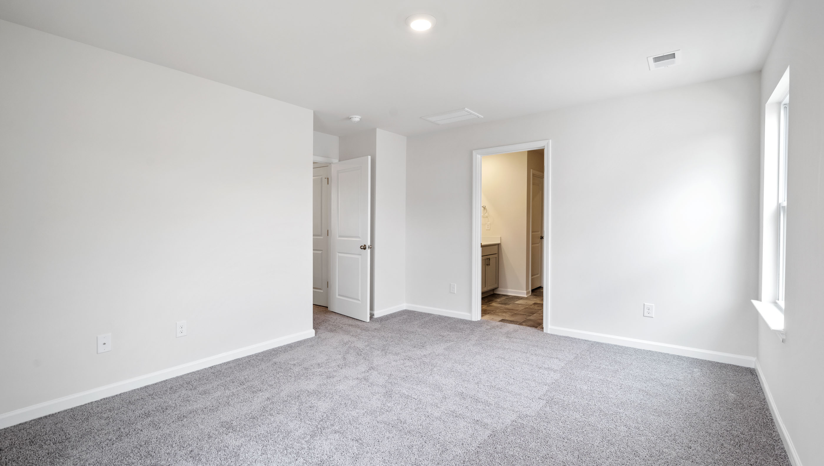 Bedroom with carpet and windows.