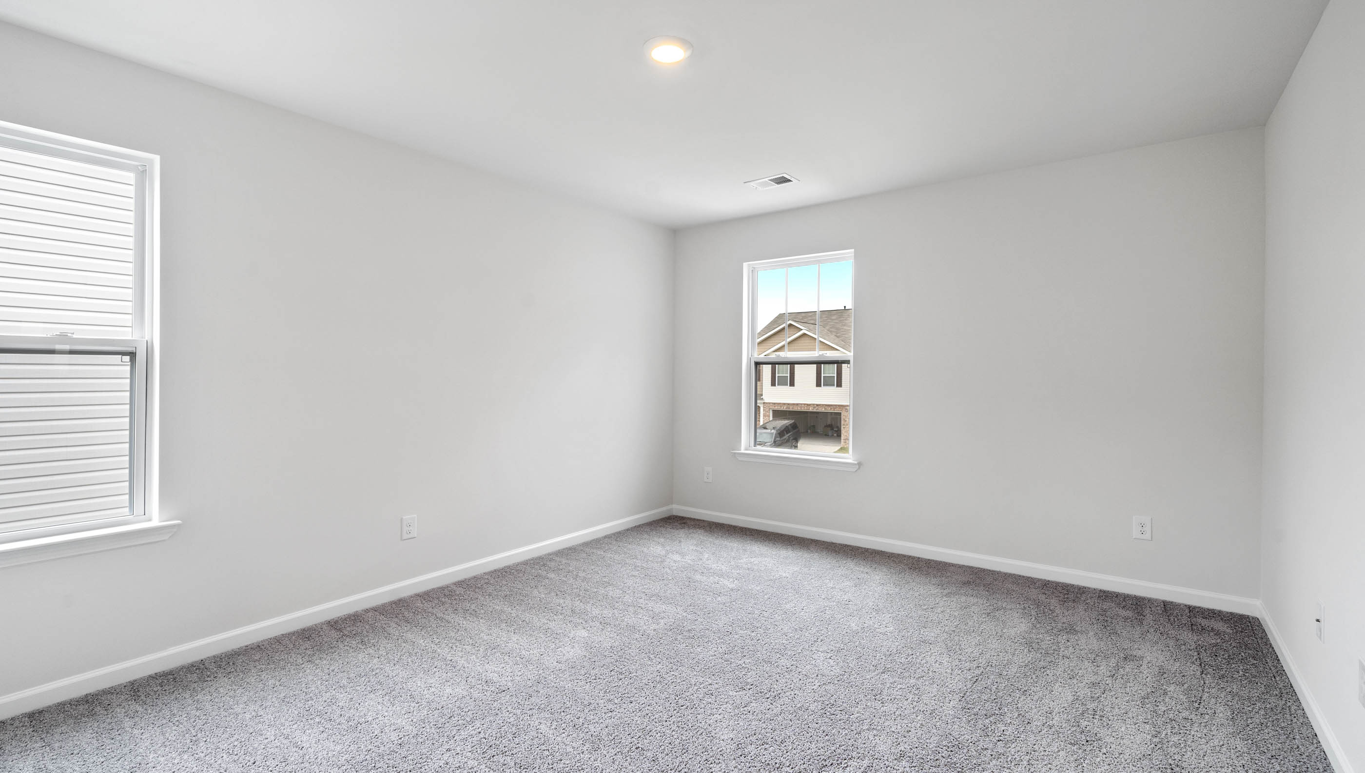 Bedroom with carpet and windows.