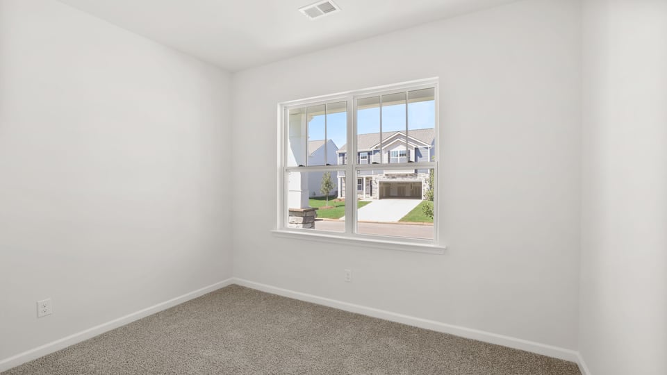 Bedroom with carpet and windows.